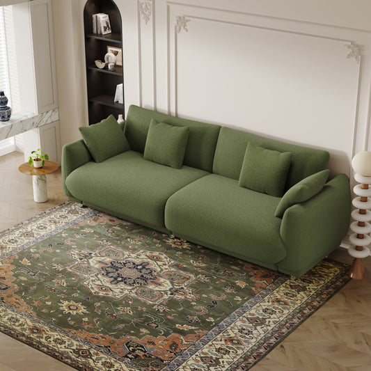 An 86.6-inch teddy wool green sofa with four throw pillows and hardware feet that can sit comfortably in an apartment bedroom wi